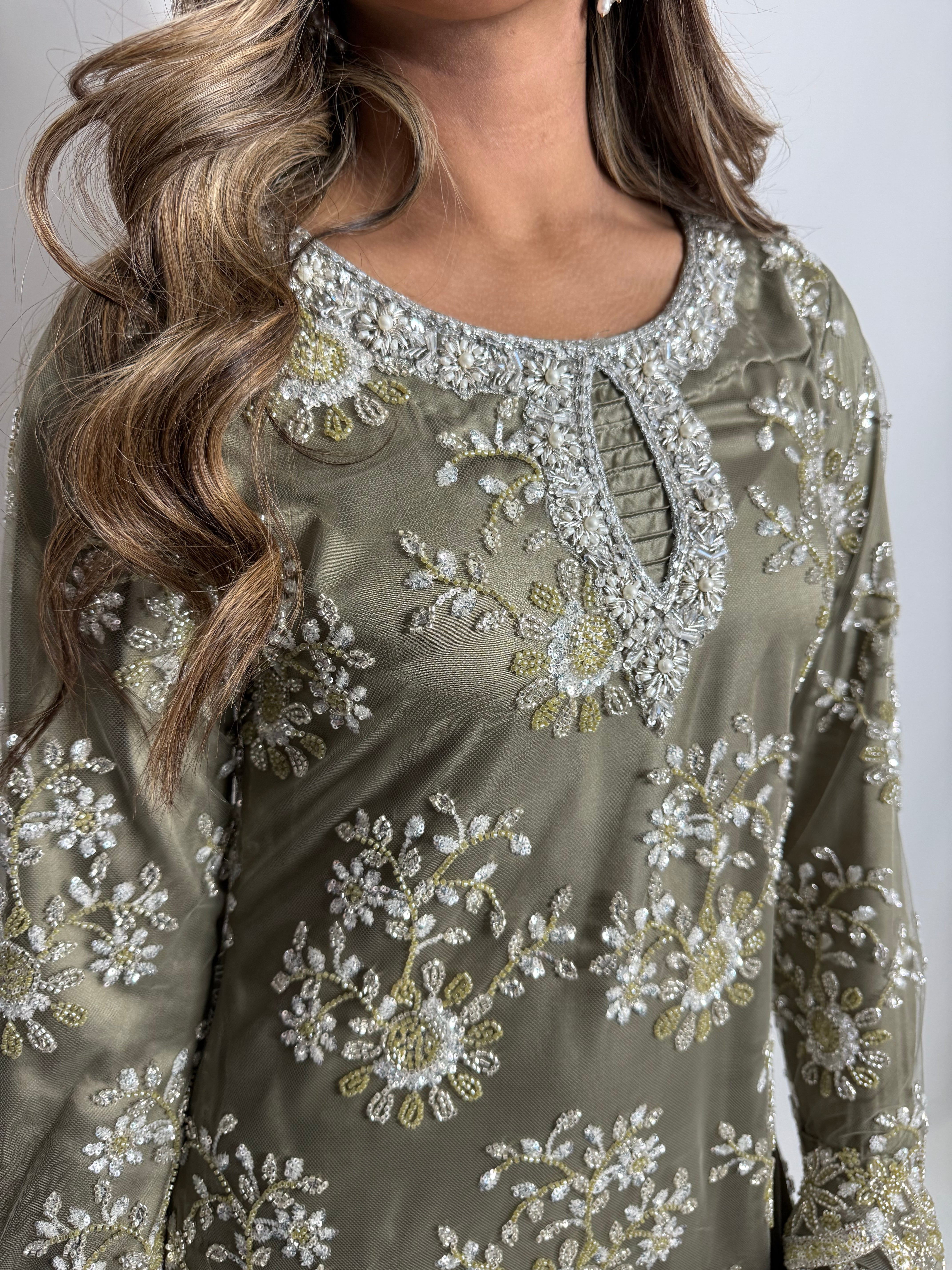 Close-up of pearl detailed neckline on olive cutdana shirt