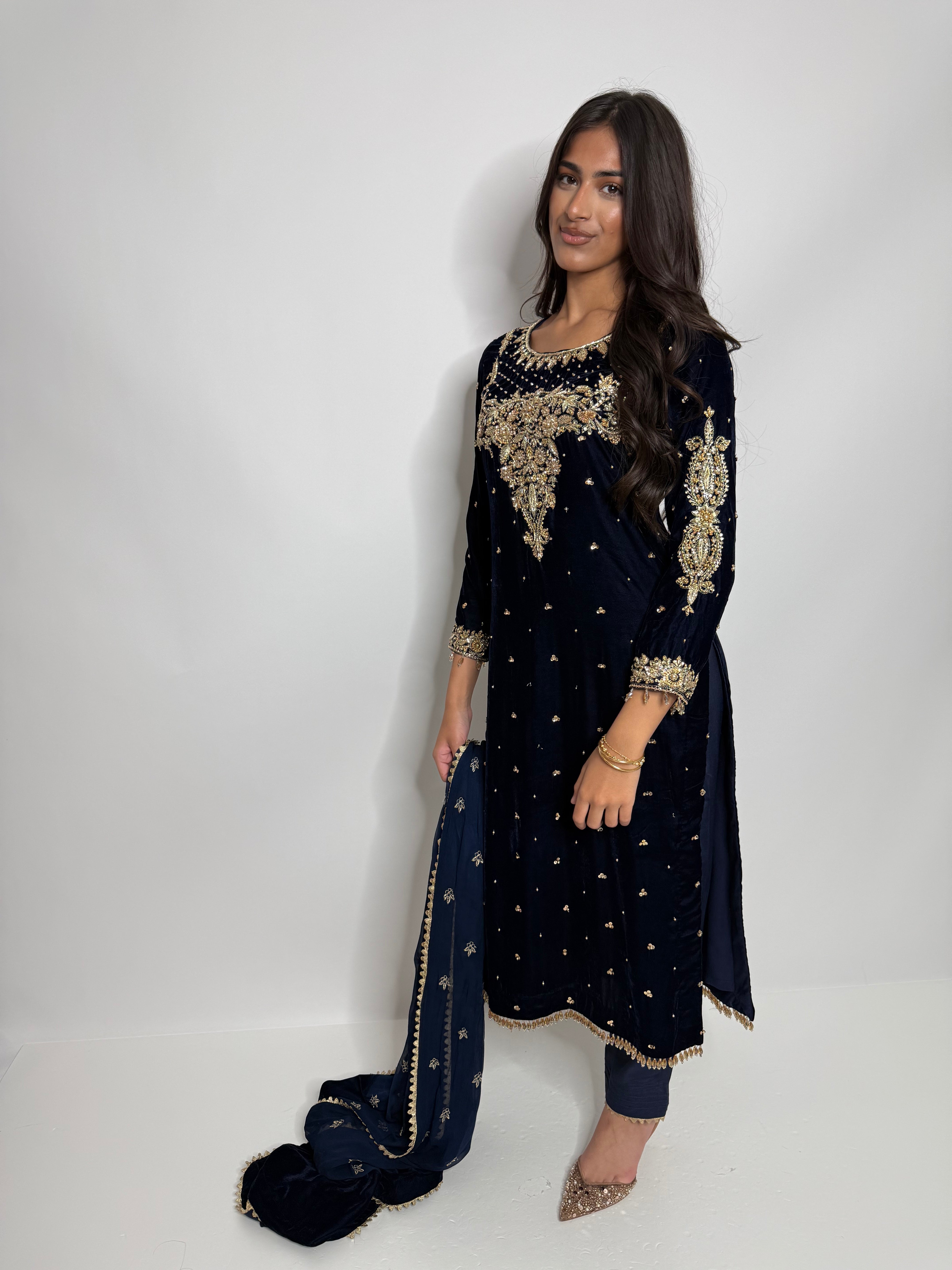 Close-up of intricate golden embroidery on navy velvet shirt.