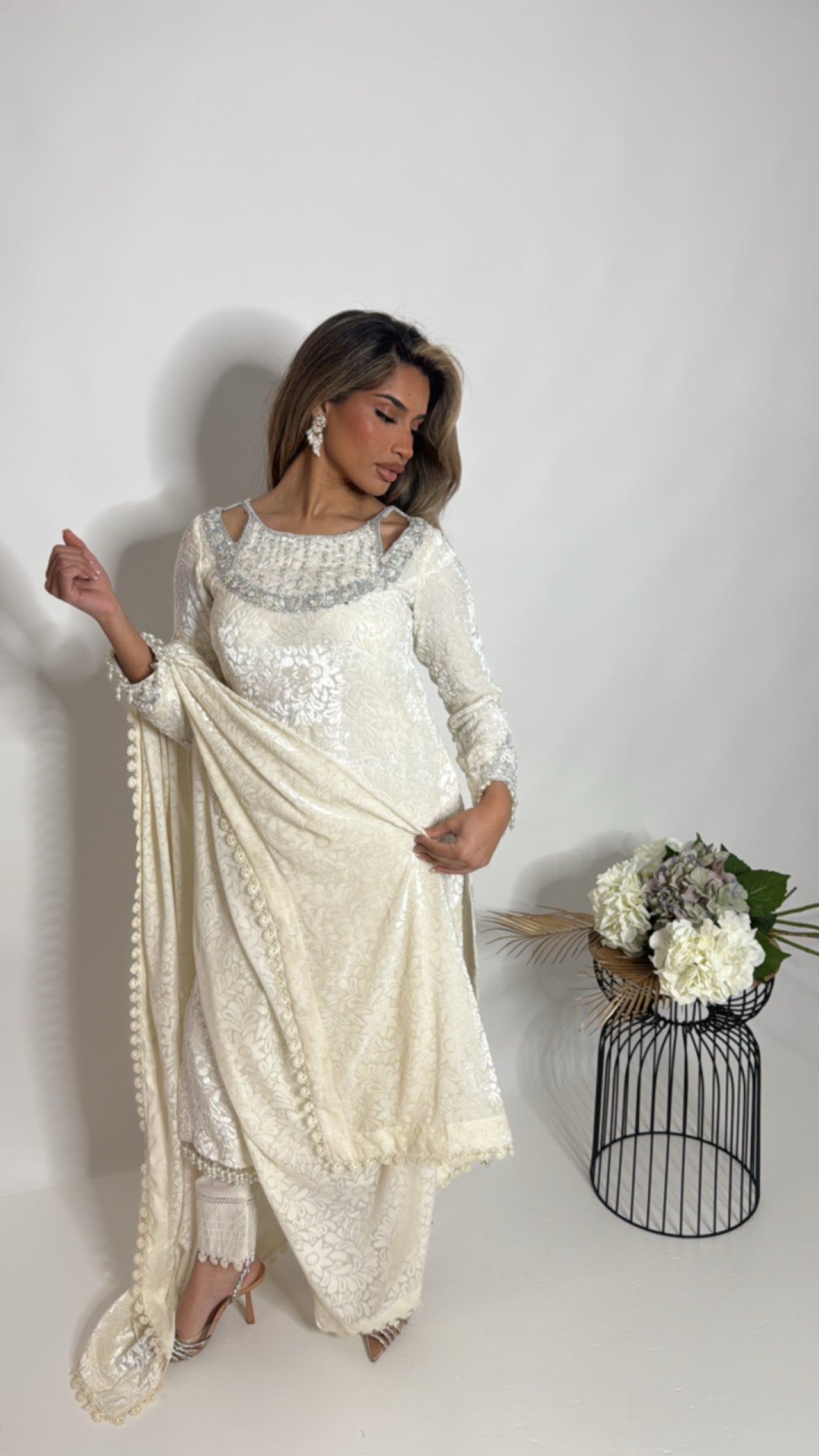 Model wearing ivory palachi Pakistani suit with hand embroidery and pearl detailing
