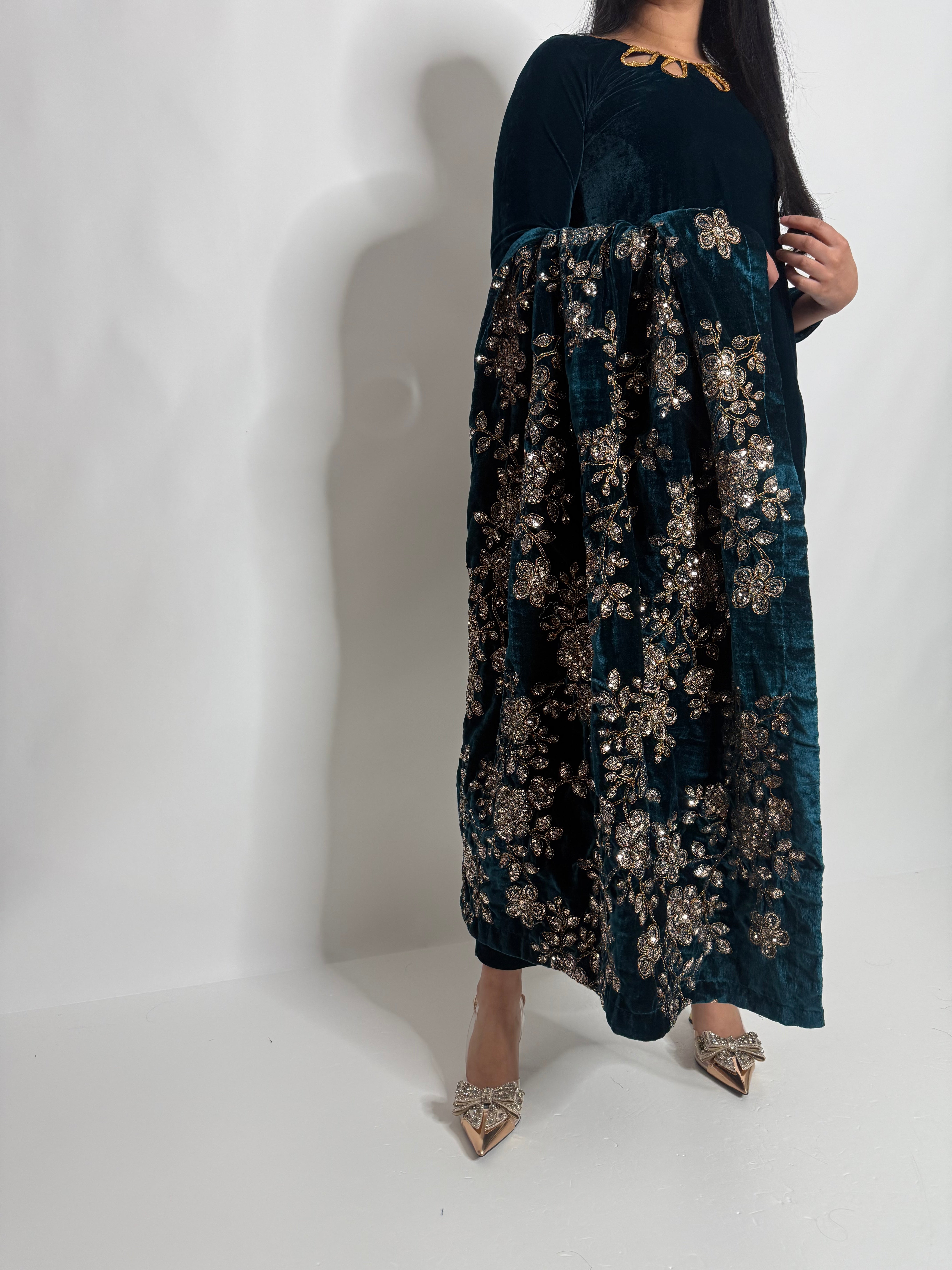 Close-up of gold floral embroidery on a teal velvet shawl, part of a formal Pakistani outfit from Ameliyana Boutique.