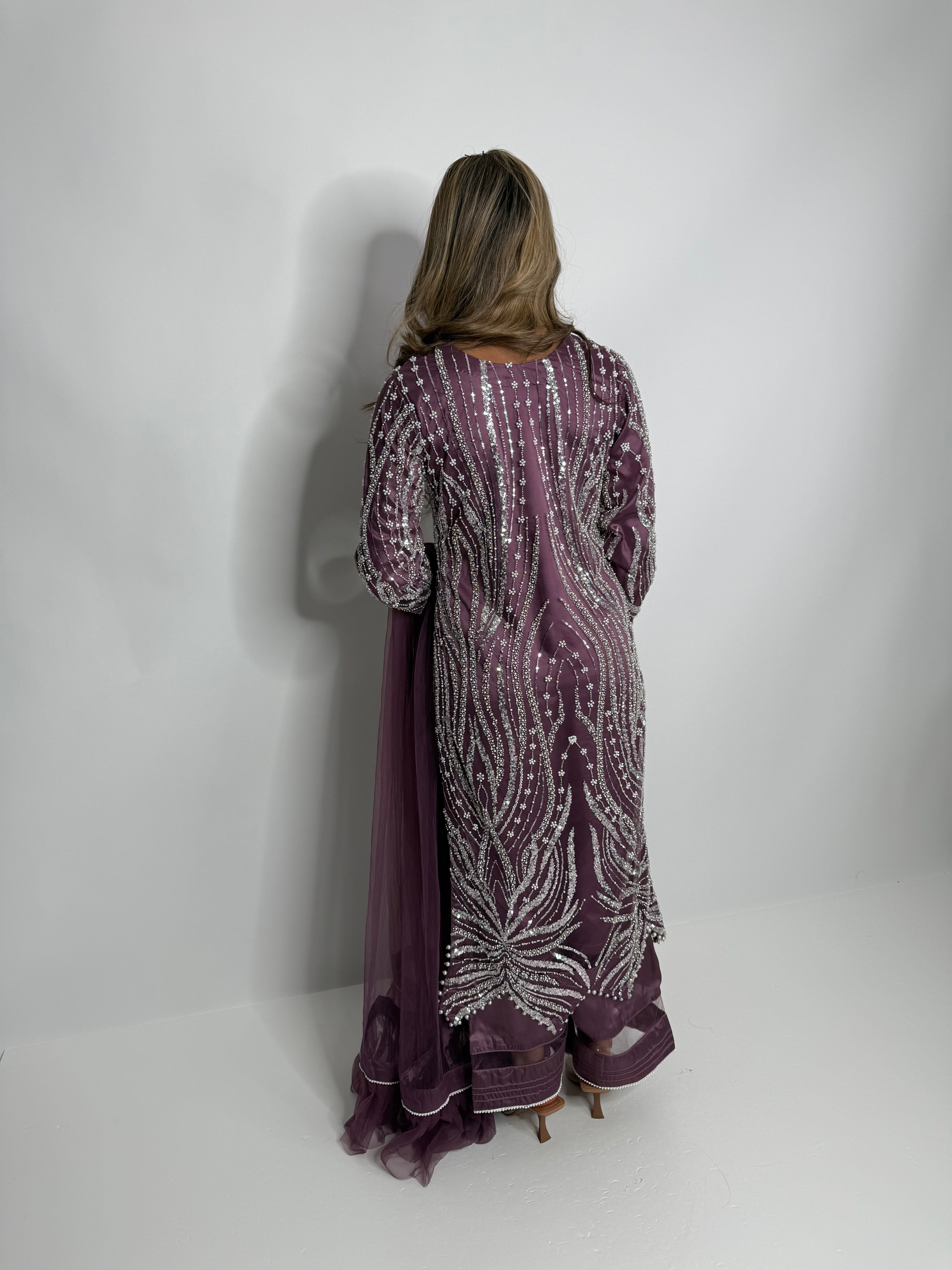 Purple Pakistani outfit with embellished shirt, pearl-trim hemline, flared silk trousers, and soft net dupatta by Ameliyana Boutique