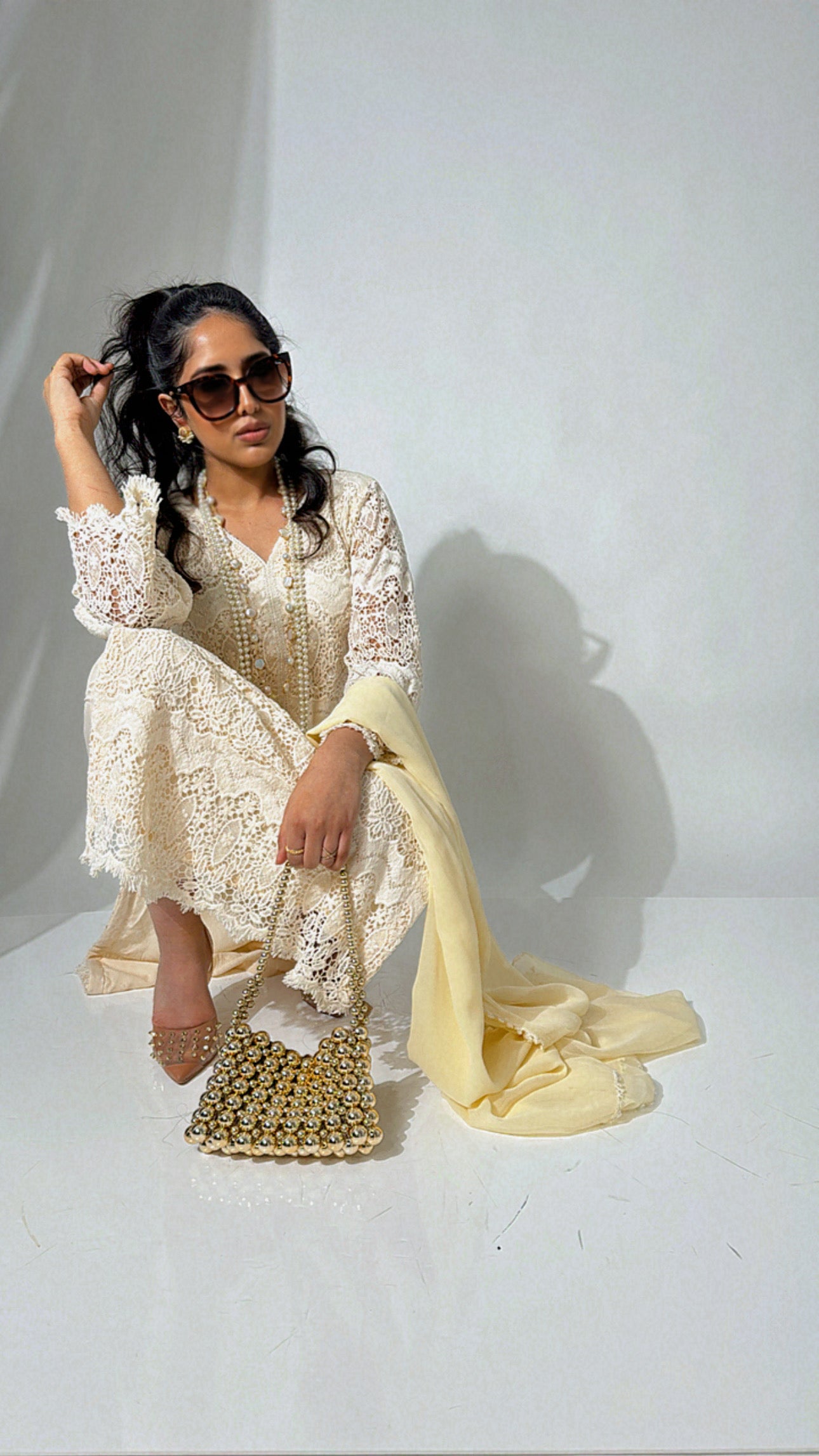 Model wearing a cream crochet-style embroidered Pakistani outfit with yellow dupatta and matching trousers — perfect for Eid or nikkah ceremonies.