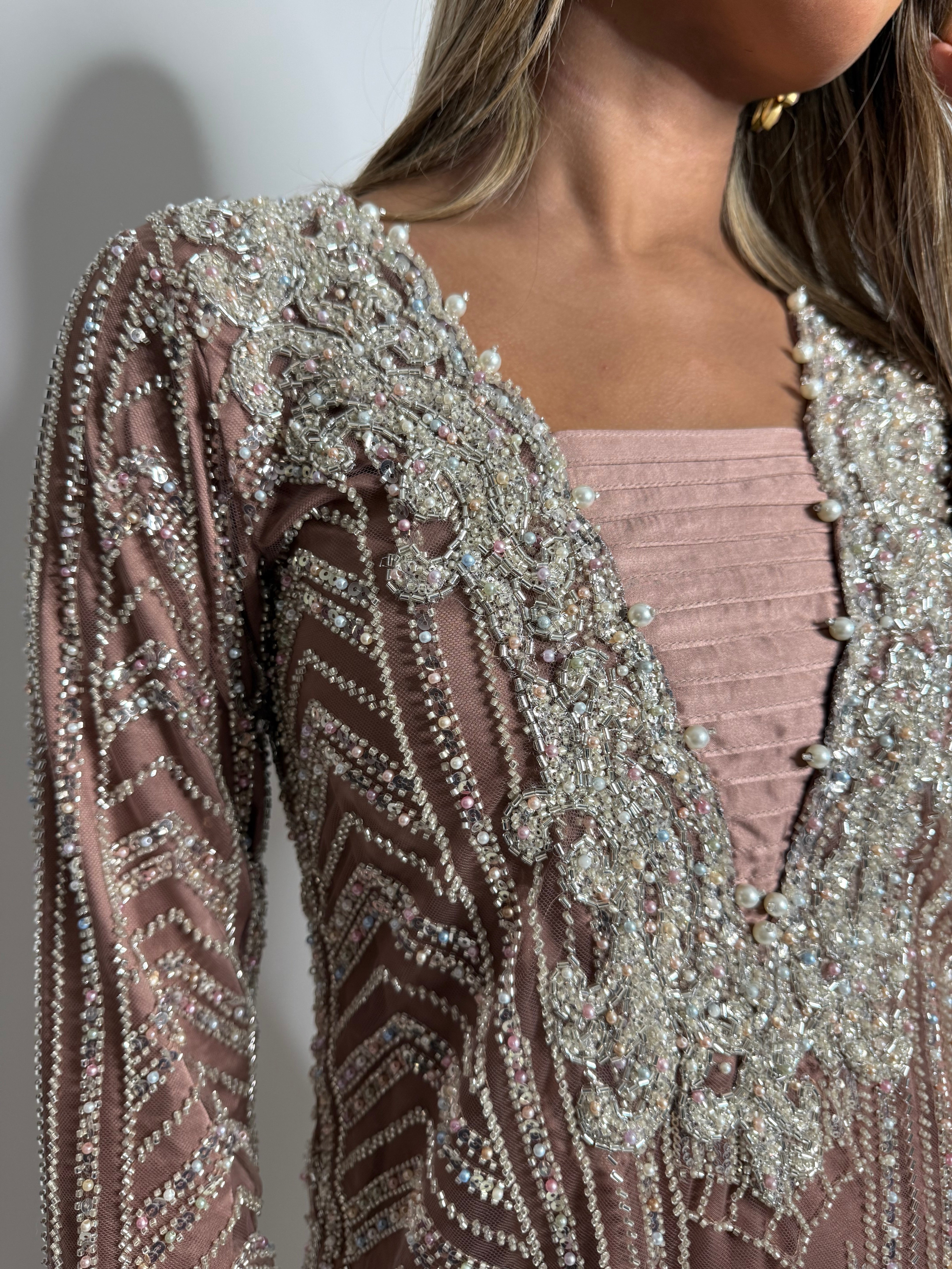 Model wearing rose-gold Pakistani suit with embroidered net dupatta