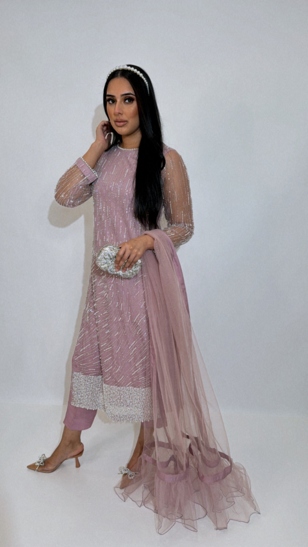 Model wearing a mauve three-piece Pakistani outfit with pearl cutdana work and net dupatta