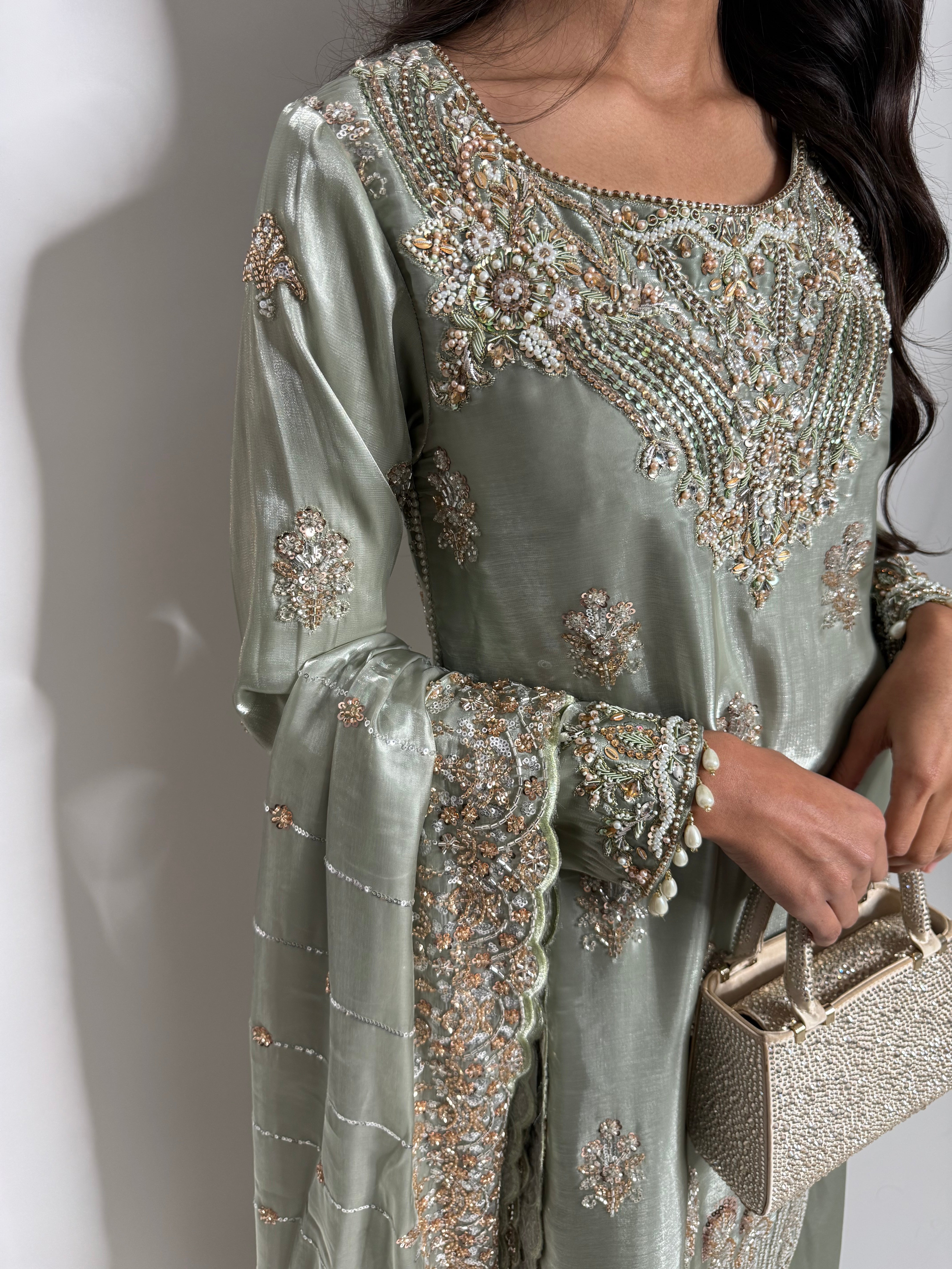 Close up of cutdana work on sage green silk fabric