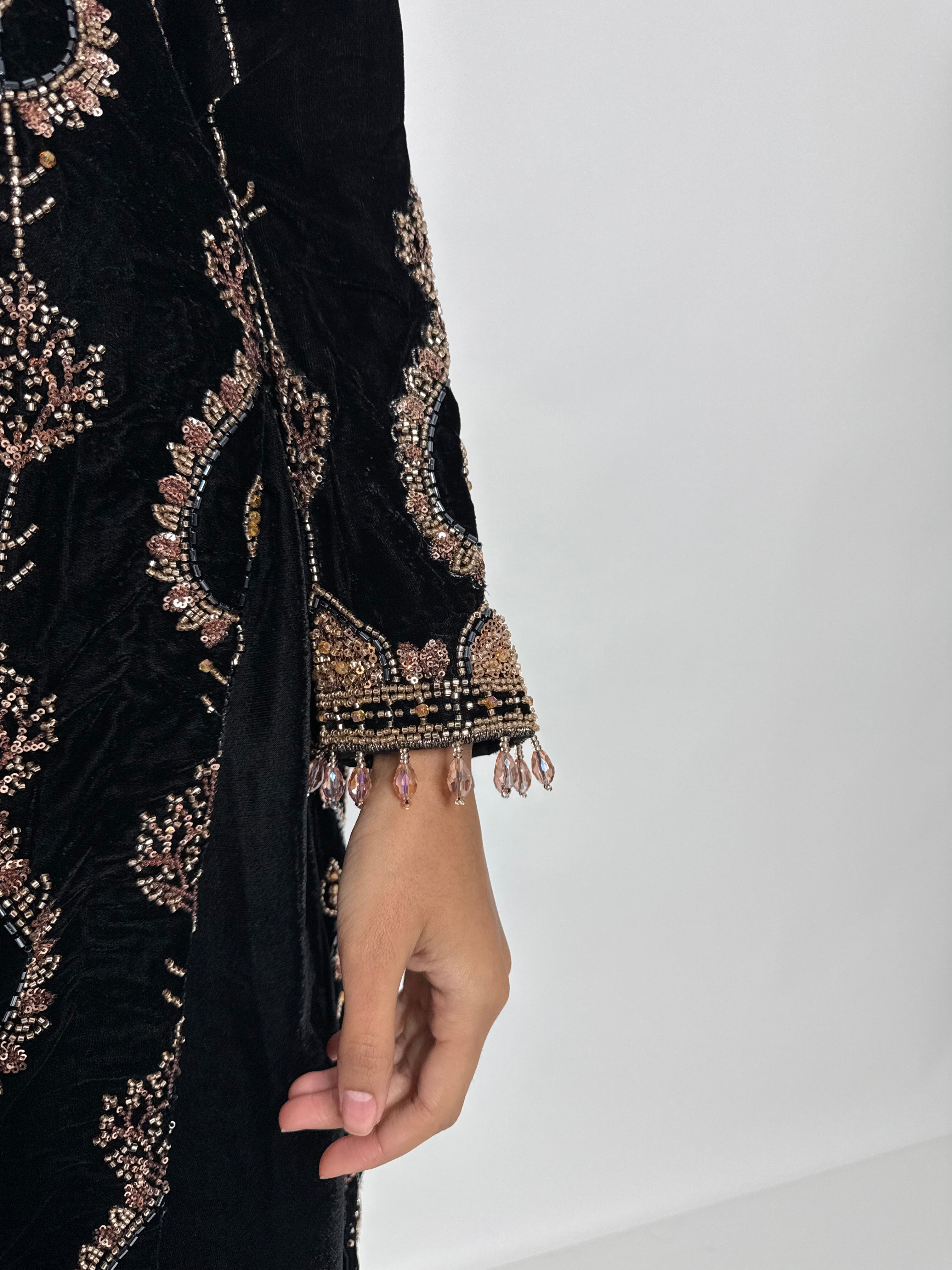 Close up of gold cutdana work on black velvet fabric